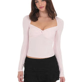 Woman wearing a light pink long-sleeve top and black skirt